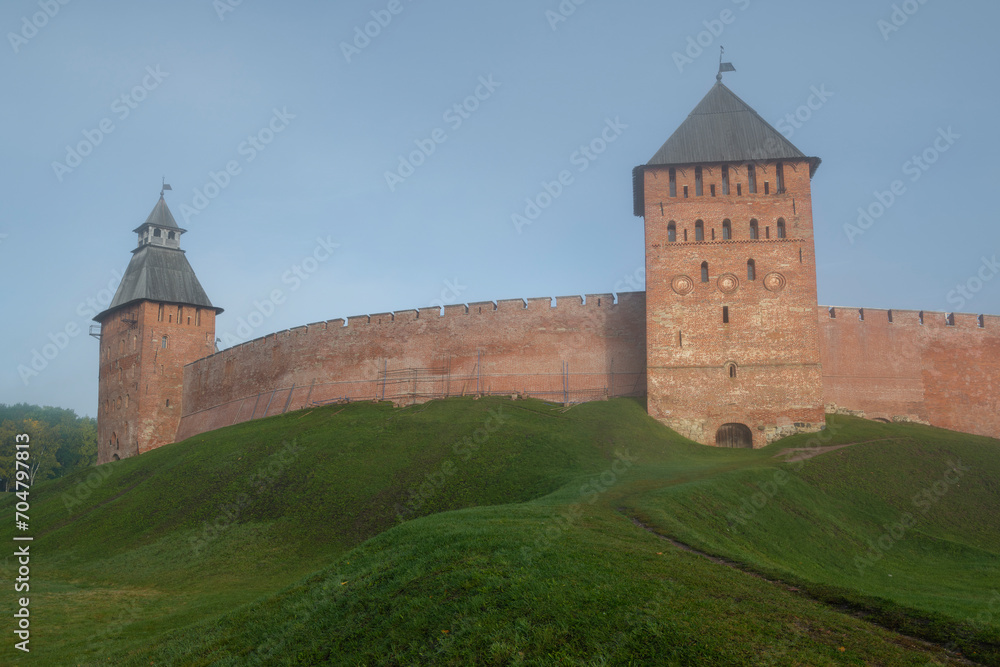 Two ancient towers of the Kremlin of Veliky Novgorod in the morning October haze. Russia