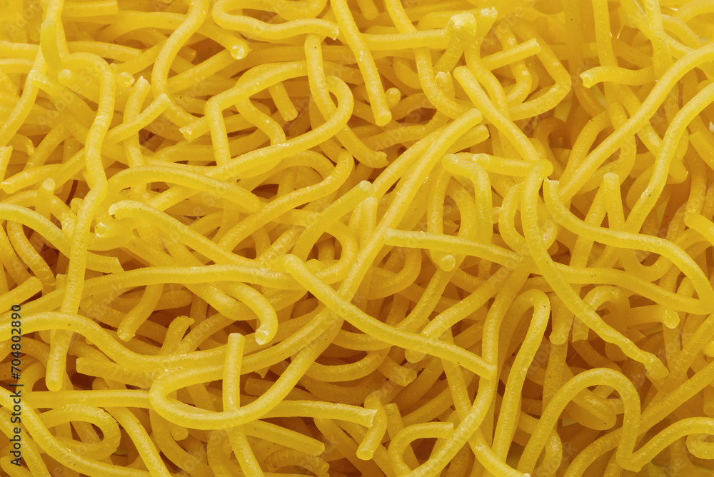 Tonnarelli pasta close-up. Bronze drawn fresh egg Italian pasta. Tonnarelli is a pasta variety similar to spaghetti alla chitarra. Tonnarelli pasta close-up. Bronze drawn fresh egg Italian pasta. Tonnarelli is a pasta variety similar to spaghetti alla chitarra.
