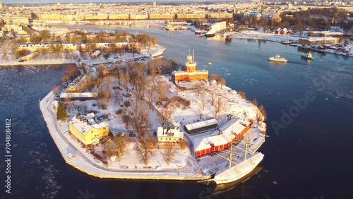  view of Stockholm, Sweden in winter, with snow. Kastell fort, kastellholmen, skeppsholmen and the old town. Morning sunlight, boat passing by. Grona lund in the distance. with spreading rights. photo