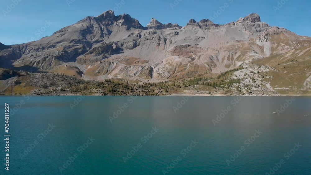 Aerial flyover the islands in the waters of Lac de Salanfe in Valais, Switzerland on a sunny autumn day in the Swiss Alps with a view of surrounding alpine peaks and cliffs. Aerial flyover the islands in the waters of Lac de Salanfe in Valais, Switzerland on a sunny autumn day in the Swiss Alps with a view of surrounding alpine peaks and cliffs.