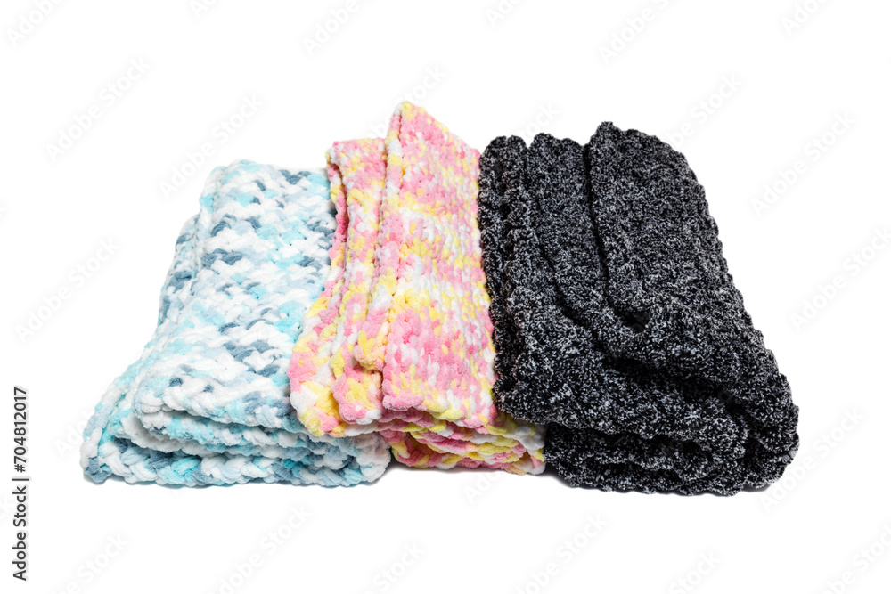 Fototapeta premium Knitted warm blankets on a white background. Handmade woven soft blankets. Texture of colored yarn.