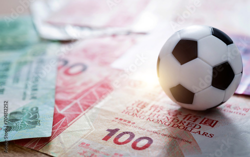 Soccer ball on stack of Hongkong dollars photo