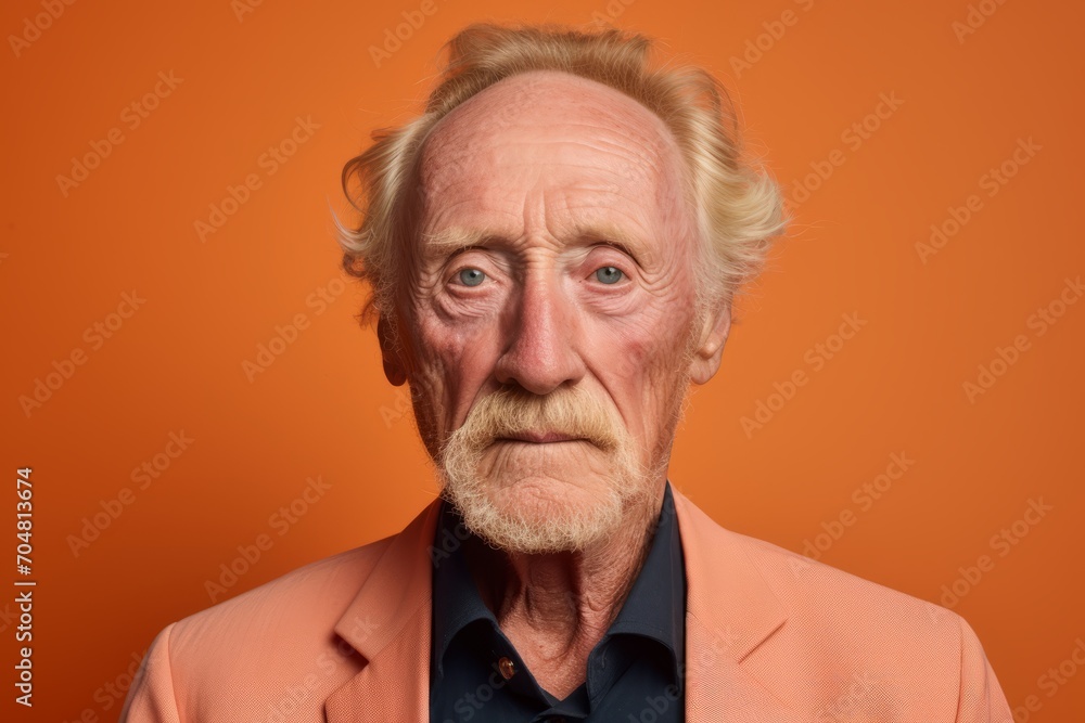 Portrait of an elderly man on a orange background. Studio shot. Portrait of an elderly man on a orange background. Studio shot.
