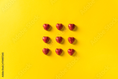 Red heart chocolates on yellow background