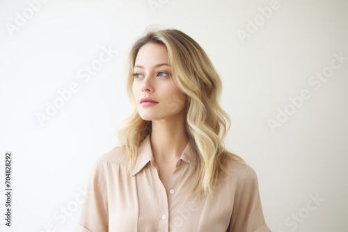 Portrait of a beautiful young blonde woman in a pink shirt.