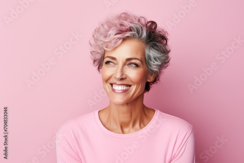 Cheerful middle aged woman with pink hair on a pink background