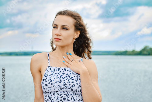Pensive woman put her arm on chest and looking away at lake © boomeart