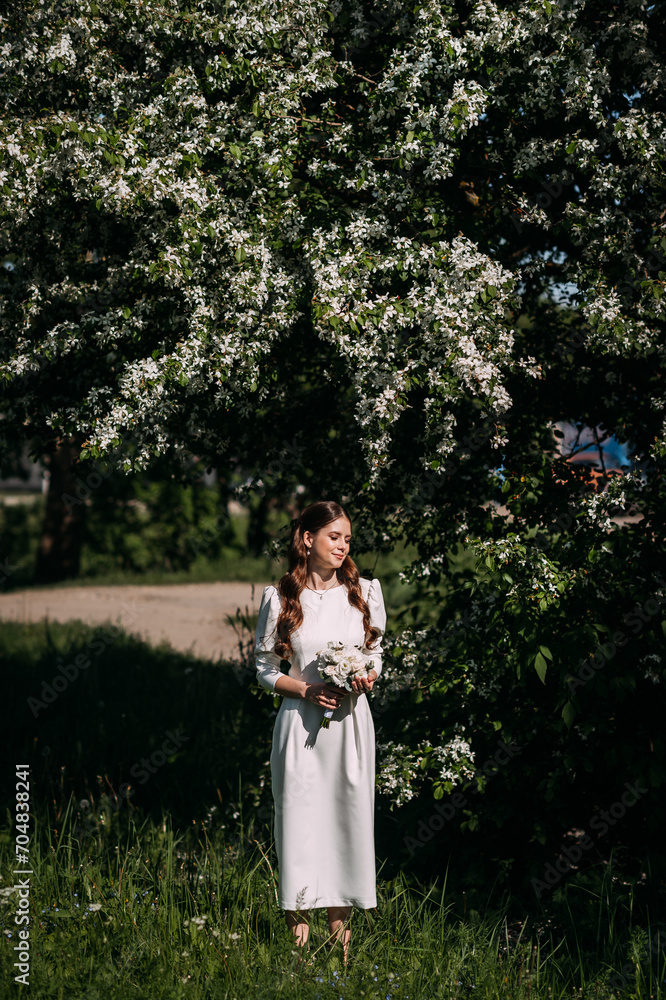 A woman wearing a white dress standing in a grassy area surrounded by trees. The setting suggests an outdoor scene, A woman wearing a white dress standing in a grassy area surrounded by trees. The setting suggests an outdoor scene,
