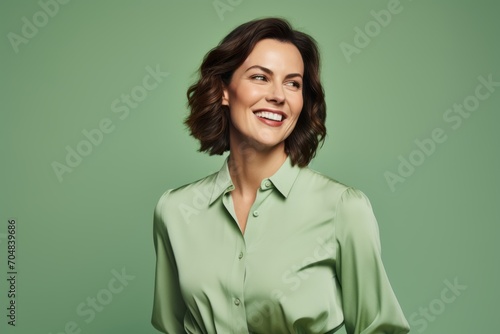 Portrait of happy smiling business woman in green shirt, over green background
