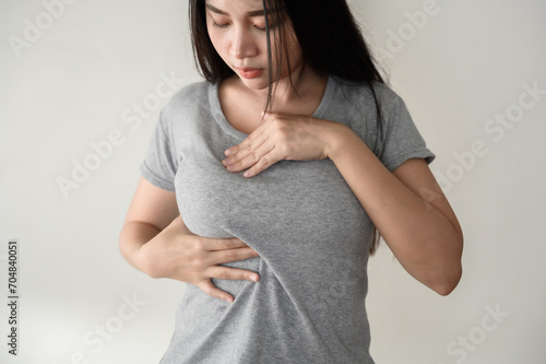 Картината върху платно Young Asian woman pressing touching her chest for checking lady breast cancer symptom diagnosis breast self exam(BSE)