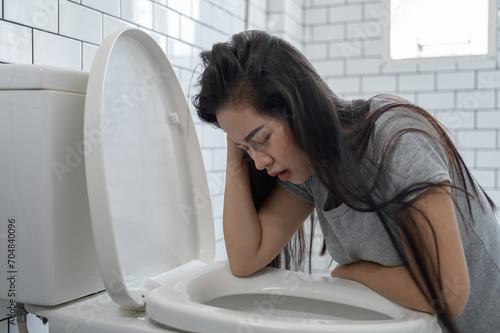 Fotografi Woman drunk hangover vomiting in toilet bowl