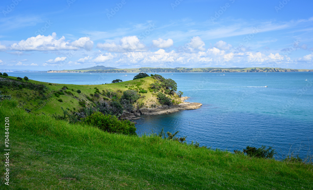 Obraz premium View of the Hauraki Gulf under a blue sky with white clouds. Waiheke Island. New Zealand.