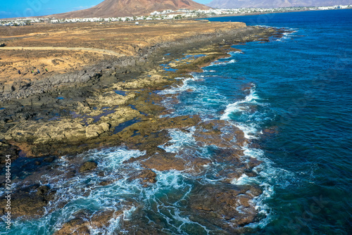 Playa Blanca coastline. Aerial drone panoramic view with Red volcano in the Background. Tourism and vacation concept. Flamingo beach  Lanzarote, Canary Islands, Spain.