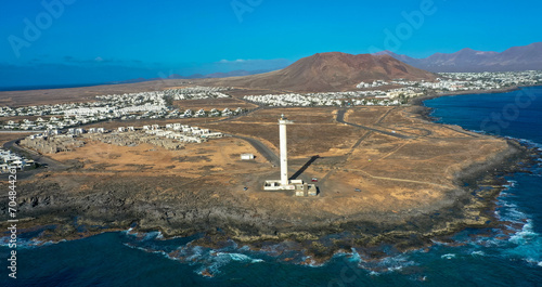 Drone photography of the lighthouse Faro de Punta Pechiguera and the beautyful playa blanca. Aerial view. Tourism and vacations concept. Lanzarote, Canary Islands, Spain.