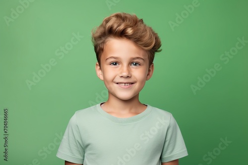 smiling little boy in green t-shirt and hairstyle on green background