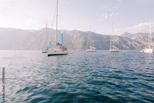 Sailing regatta at sea with a mountain range in the background