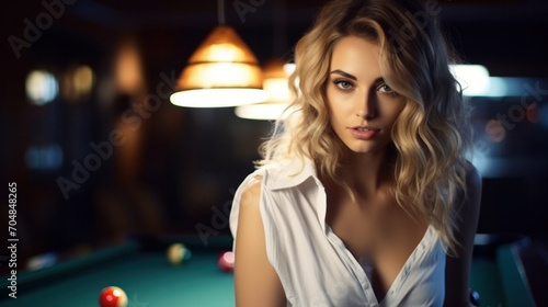 Blond woman posing with table with green surface in billiard club. Pool game snooker pyramid player photo