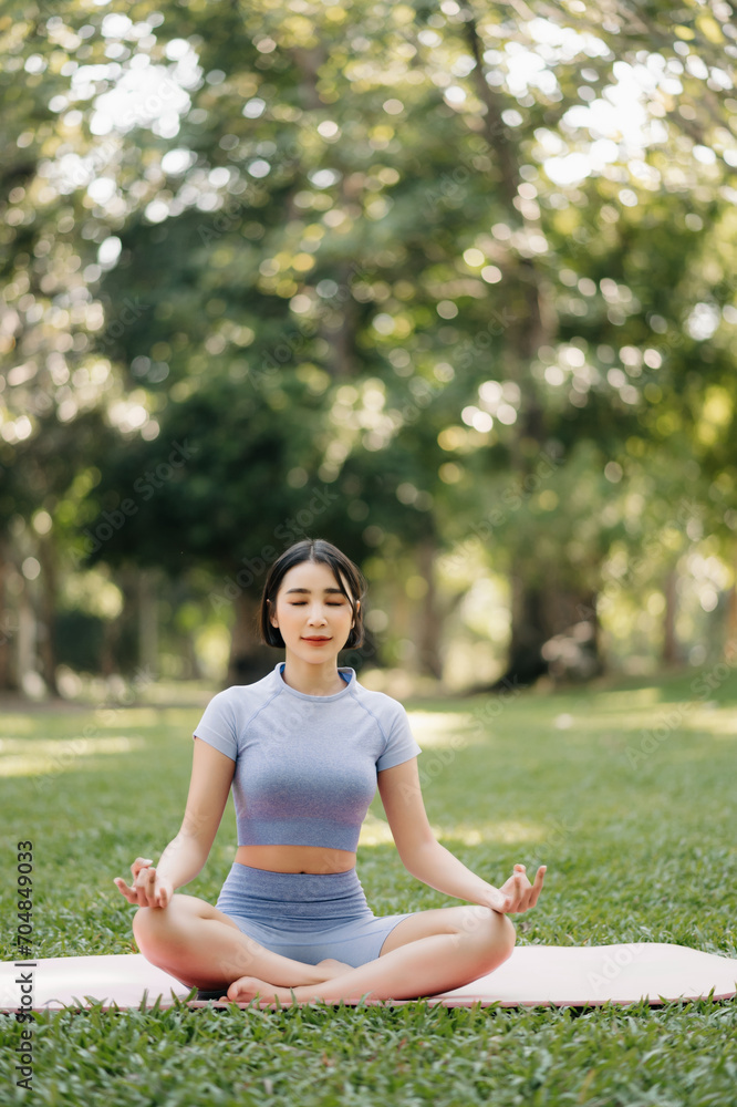 Portrait of young woman practicing yoga in garden.female happiness.  in the park blurred background.