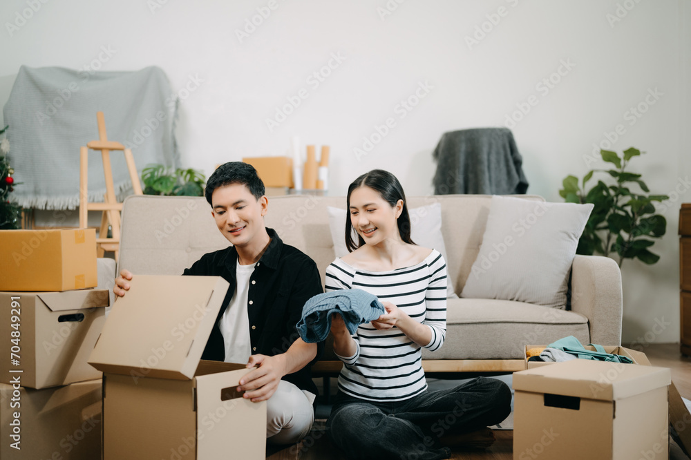 Asian young attractive couple man and woman use tablet and smartphone online shopping furniture decorate house with carton package move Asian young attractive couple man and woman use tablet and smartphone online shopping furniture decorate house with carton package move