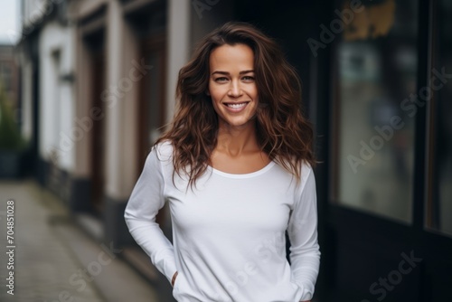 Portrait of beautiful young woman smiling and looking at camera in the city