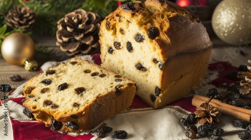 a loaf of bread with raisins on a table next to a pine cone and a christmas ornament.