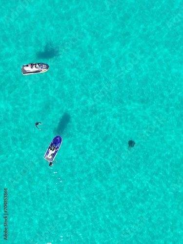 Peaceful scene of a cluster of boats drifting in the tranquil blue sea
