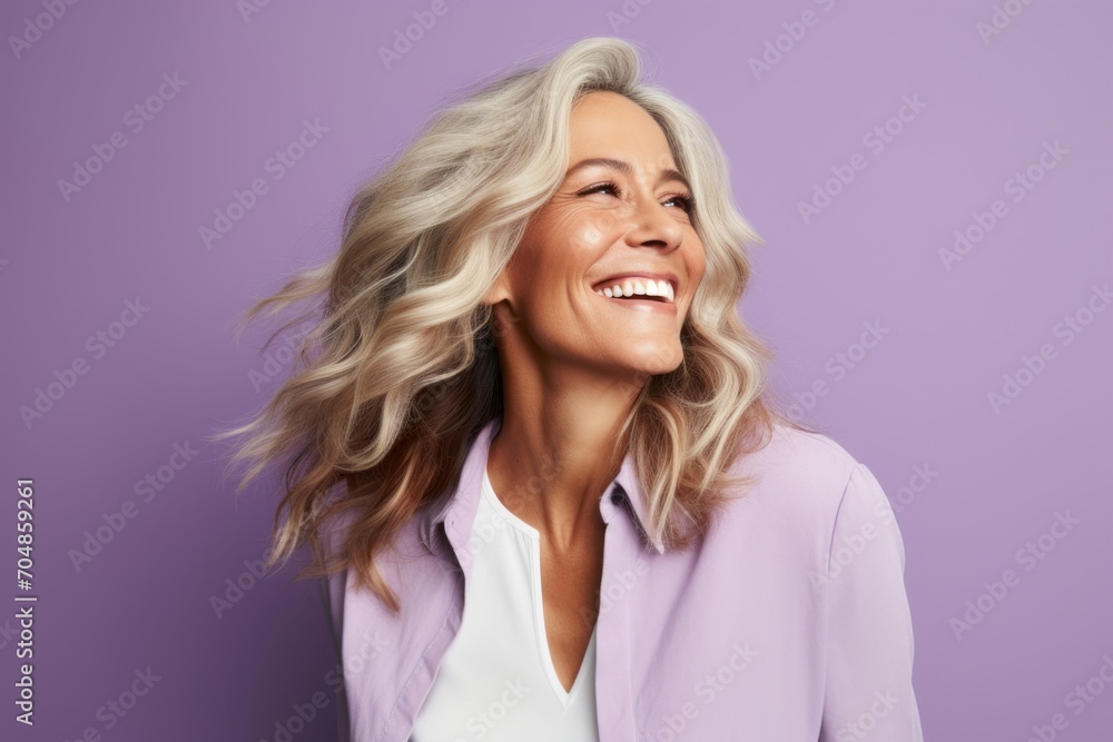 Happy mature businesswoman with long blond hair on a purple background. Happy mature businesswoman with long blond hair on a purple background.