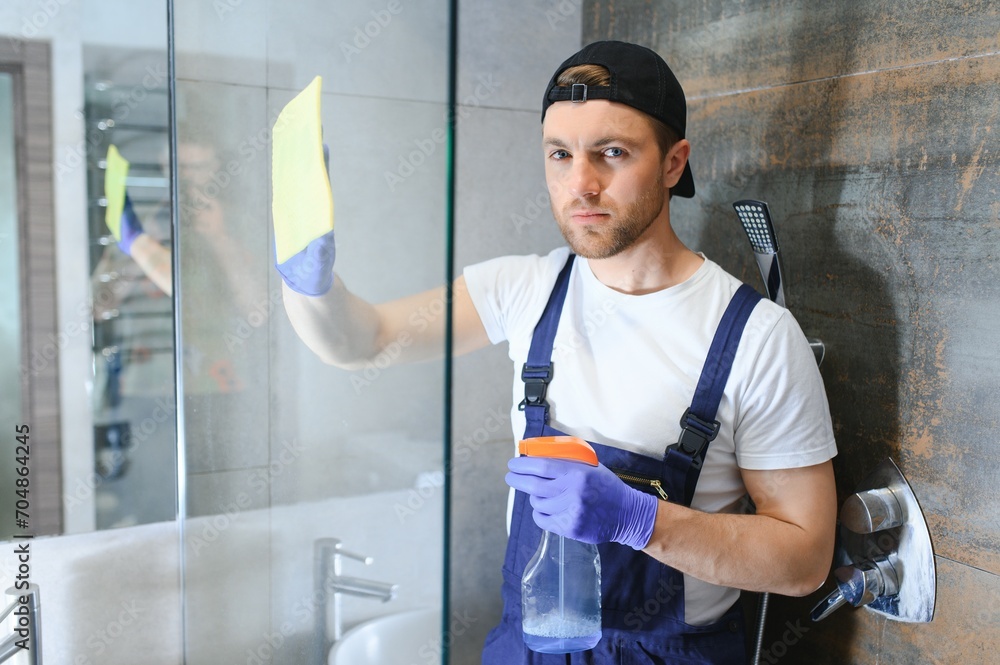 An employee of the cleaning service cleans the bathroom.
