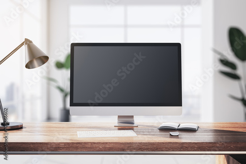 Modern designer table with computer monitor, coffee cup, supplies, other objects and window with city view in the background. Mock up, 3D Rendering.
