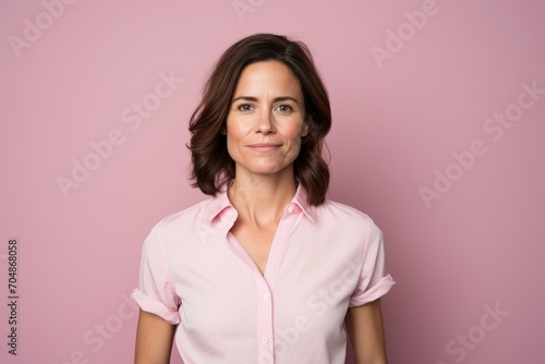 Portrait of a confident businesswoman looking at the camera over pink background