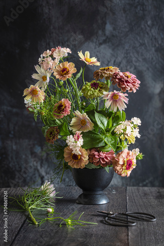 Blooming zinnias and cosmos flowers in vase photo