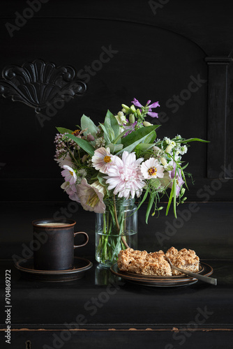 Mug of coffee, pieces of apple pie and blooming flowers in jar photo