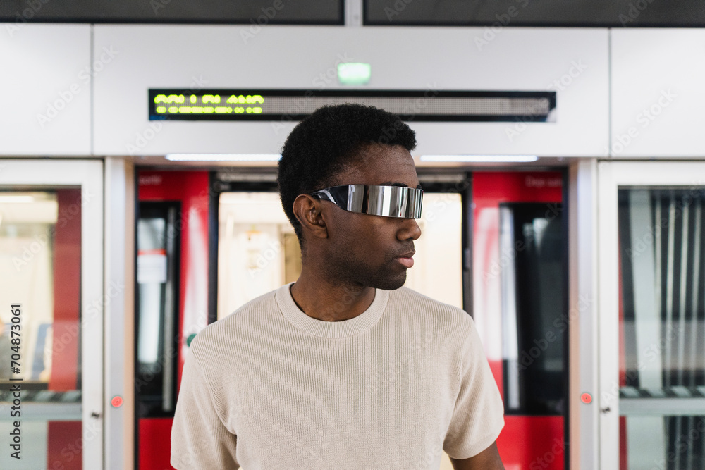 Cyberpunk wearing augmented reality glasses diembarking from metro train Cyberpunk wearing augmented reality glasses diembarking from metro train