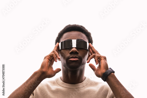 Cool young man wearing cyber glasses against white background putting fingers on temples photo