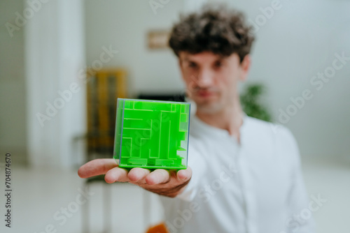 Businessman showing cube shape maze in office photo