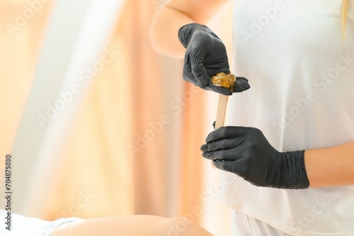 Portrait of a female caucasian beautician holding a jar of sugar paste for sugaring