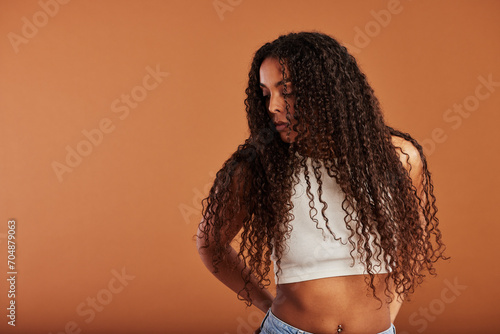 Young black woman looking sideways against an orange background photo