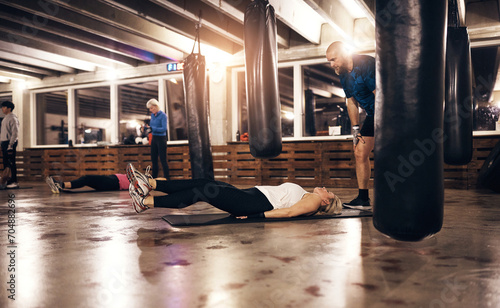 People doing ab workouts with partners on a boxing gym floor photo