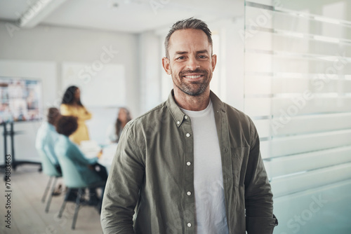 Businessman smiling outside of a boardroom before meeting with coworkers photo