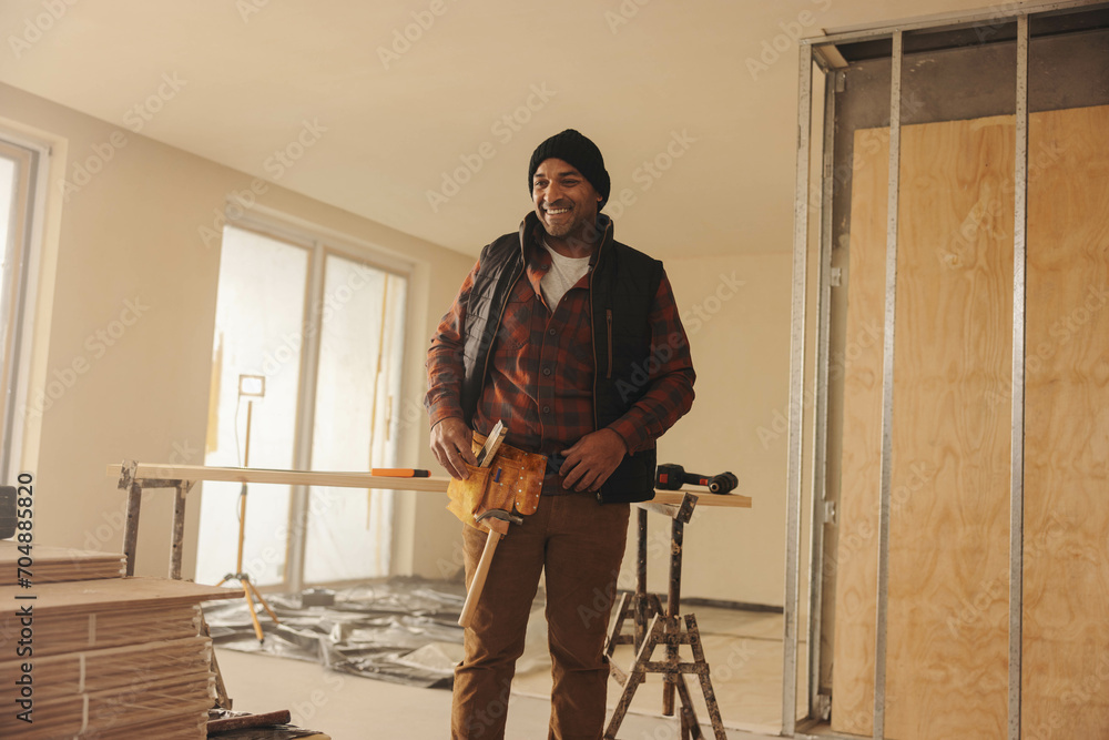 Happy man renovating his kitchen interior with a tool belt