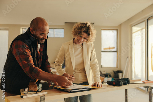 Home renovation professional signing a contract with a homeowner