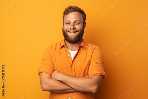 Handsome young man in orange t-shirt on yellow background