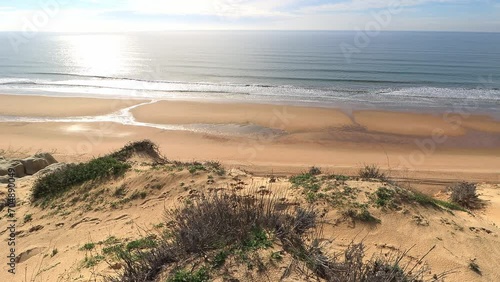 Arenosillo beach, located in Huelva, Spain. Explore the serene beauty of this coastal paradise with its sunlit sandy shores and the rhythmic ebb and flow of the Atlantic Ocean. photo