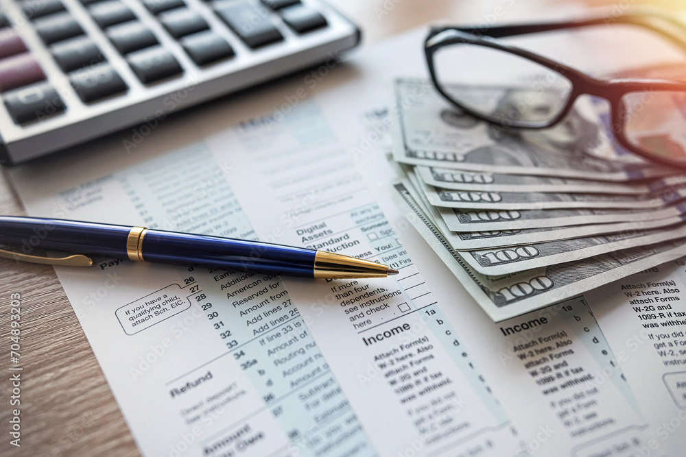 2023 tax form 1040 us money and glasses, taxation concept 2023 tax form 1040 us money and glasses, taxation concept