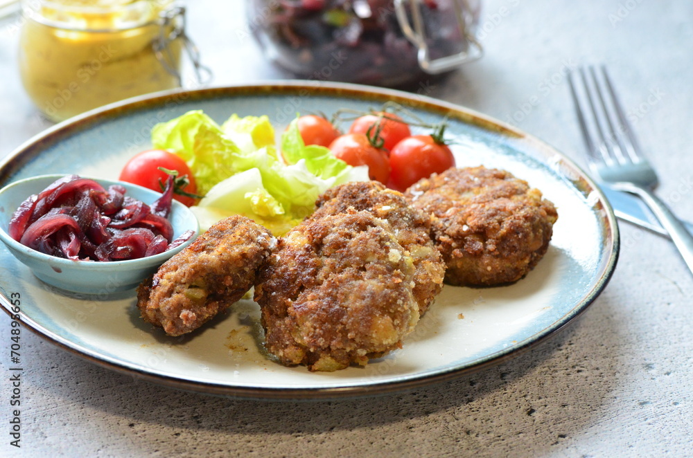 Meatballs with salad and cherry tomatoes on a plate. Selective focus.