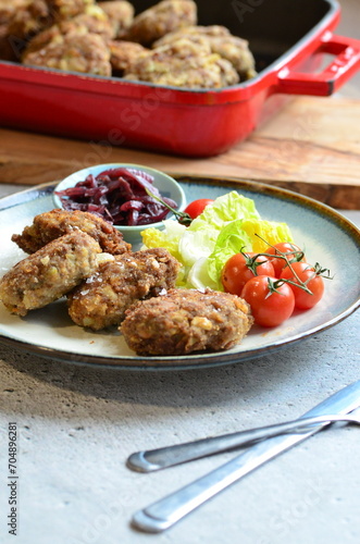 Meatballs with salad and cherry tomatoes on a plate. Selective focus.