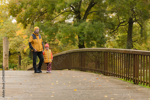father and five-year-old daughter in fall park on bridge