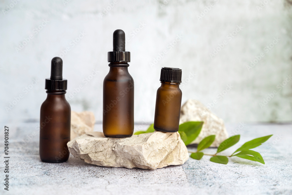 Amber Glass bottle with dropper lid with cosmetic product serum on stone. Beauty concept Amber Glass bottle with dropper lid with cosmetic product serum on stone. Beauty concept