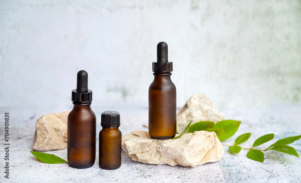 Amber Glass bottle with dropper lid with cosmetic product serum on stone. Beauty concept Amber Glass bottle with dropper lid with cosmetic product serum on stone. Beauty concept