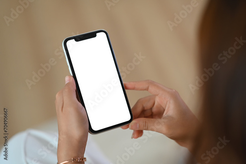 Closeup young woman holding mobile phone with white empty screen for application advertising
